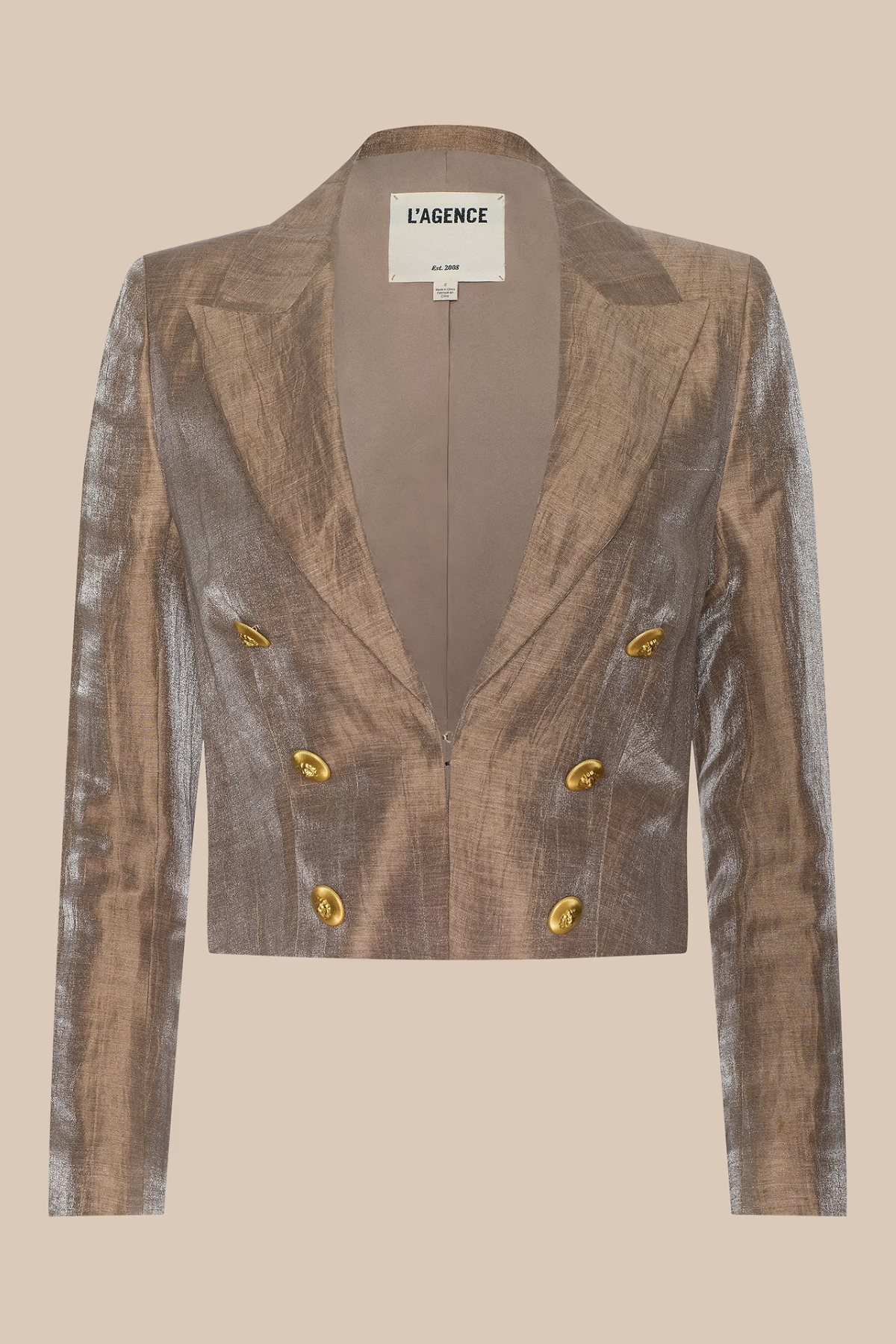 A cropped double-breasted blazer in a metallic bronze fabric with gold buttons, shown flat against a solid beige background. The brand label 'L'AGENCE' is visible at the collar.
