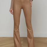 Person wearing brown flared pants and a matching top on a wooden floor with a white wall background.