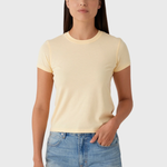 Woman wearing a light yellow t-shirt and denim shorts on a white background