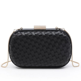 Black woven leather clutch bag with a gold-tone metal clasp and a thin gold shoulder strap, shown against a plain white background.