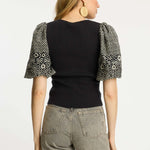 Black short-sleeve top with a clean neckline and soft drape