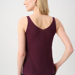 Woman wearing a burgundy tank top against a light gray background