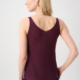 Woman wearing a burgundy tank top against a light gray background