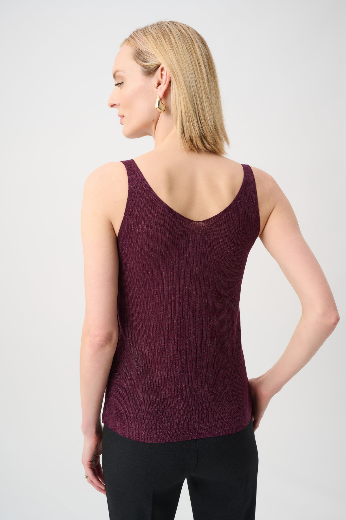 Woman wearing a burgundy tank top against a light gray background