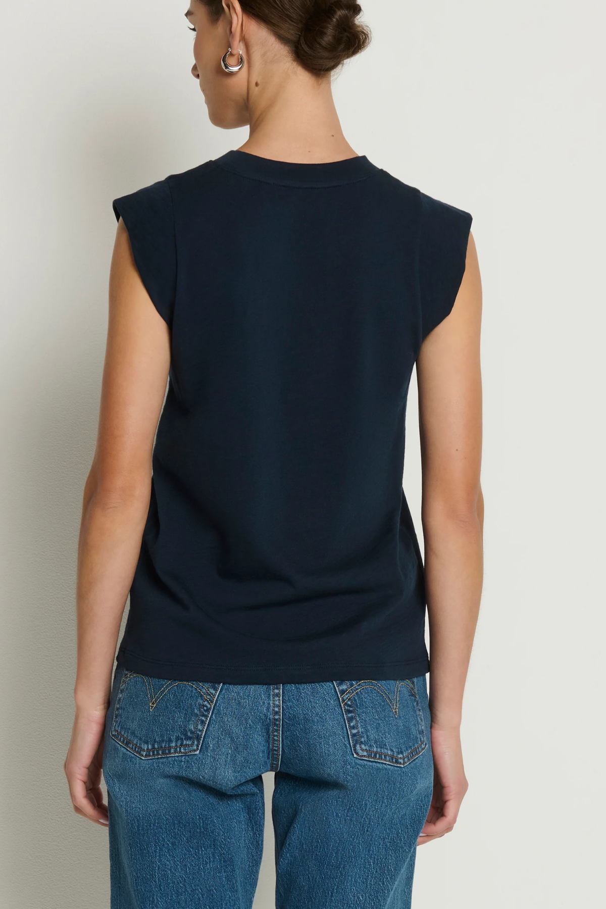 Model wearing a navy sleeveless muscle tank with a relaxed fit.