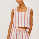 Woman wearing a striped sleeveless top and pants on a white background