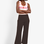 Model wearing slim-fit ankle-length pants styled with a sleeveless top for a polished contemporary look.