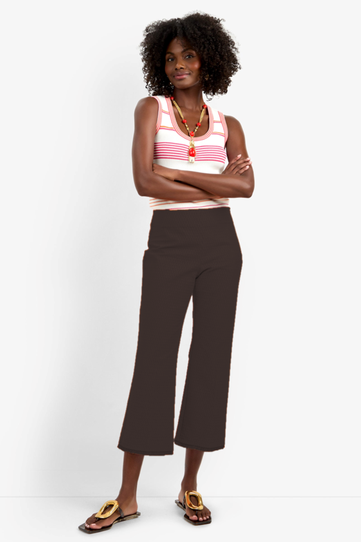 Model wearing slim-fit ankle-length pants styled with a sleeveless top for a polished contemporary look.