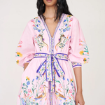 Woman wearing a pink floral robe against a white background