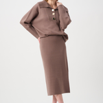 Woman wearing a brown outfit with a top and skirt on a white background