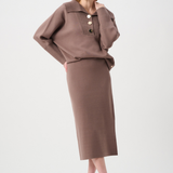 Woman wearing a brown outfit with a top and skirt on a white background