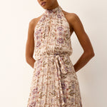 Woman wearing a floral dress against a plain background