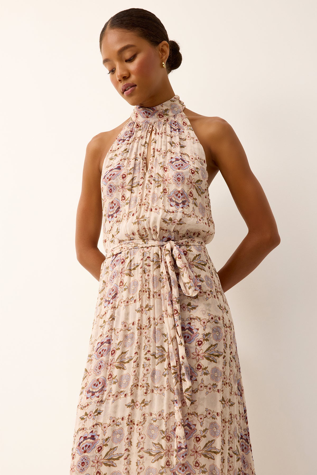 Woman wearing a floral dress against a plain background