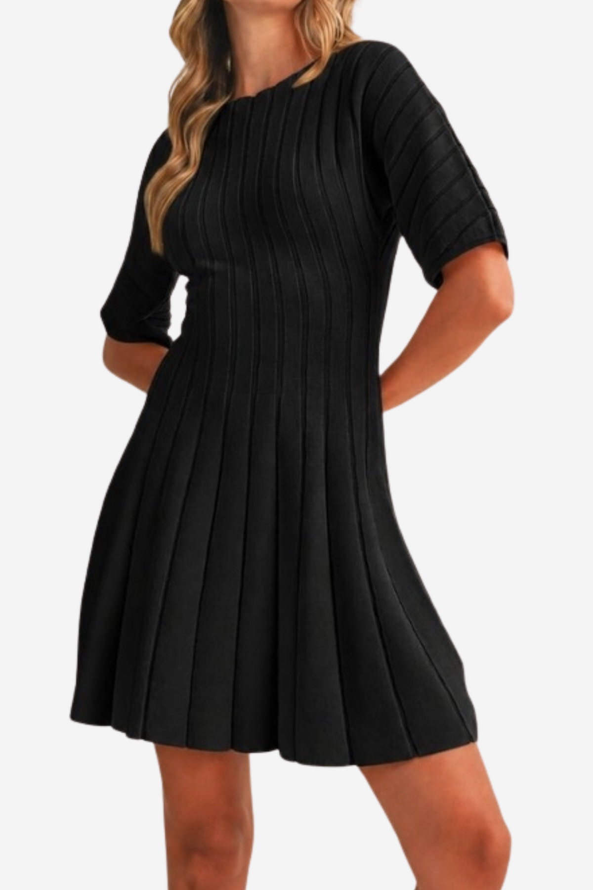 A woman wearing a black pleated short-sleeve dress with a crew neck, shown from the shoulders to mid-thigh against a plain light background.