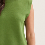 Green sleeveless top worn by a person on a plain background