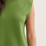 Green sleeveless top worn by a person on a plain background