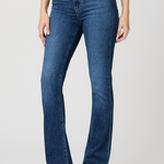Person wearing blue jeans on a plain background