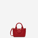 Small structured red tote bag with dual top handles and a compact, polished silhouette.