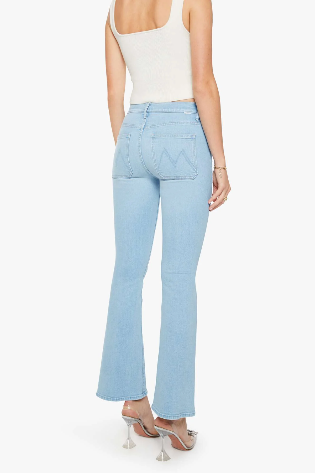 back of woman in blue denim and white tank top on white background 
