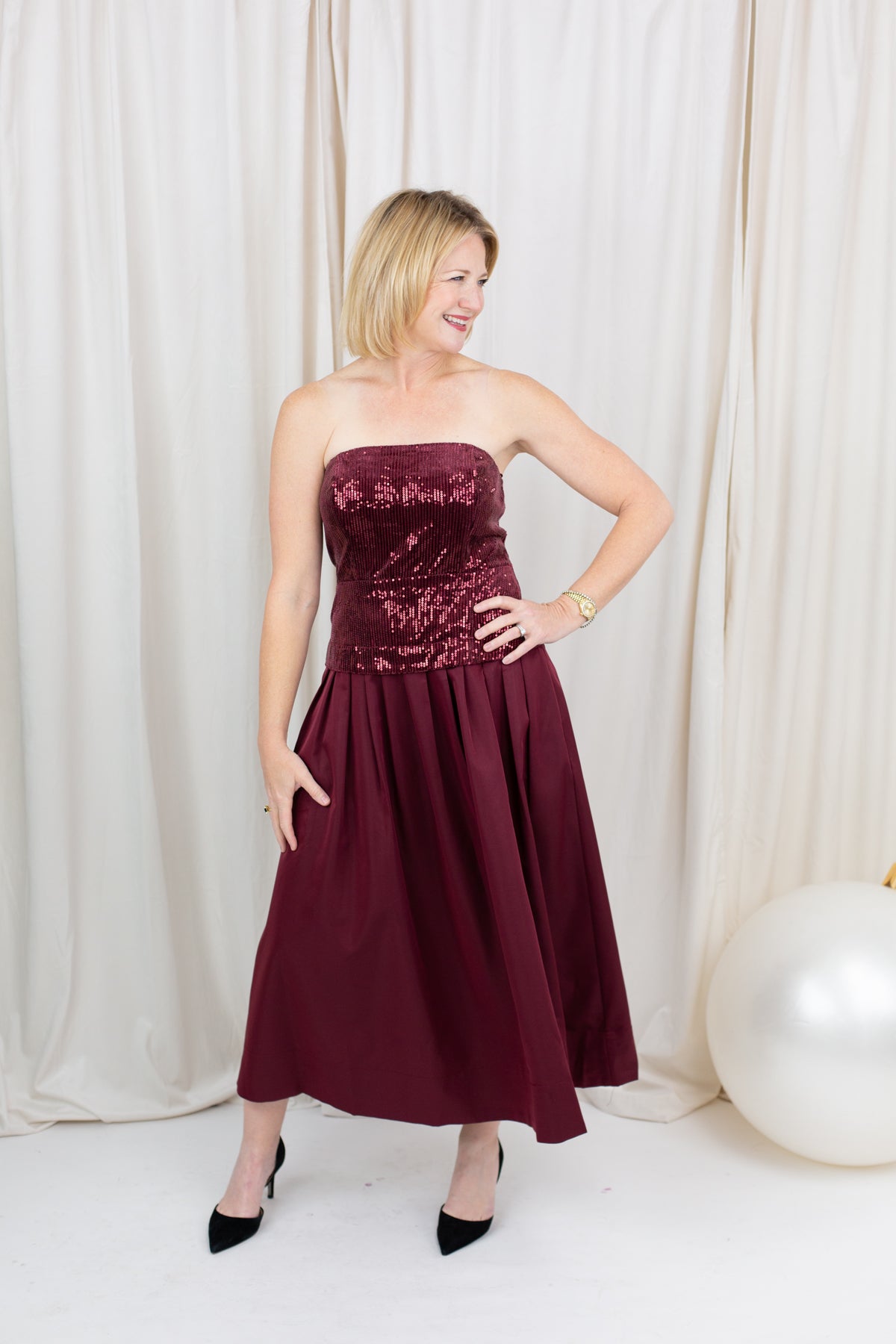 Burgundy sequin dress for evening wear paired with heels