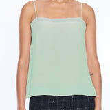 woman in mint green tank top on white background 