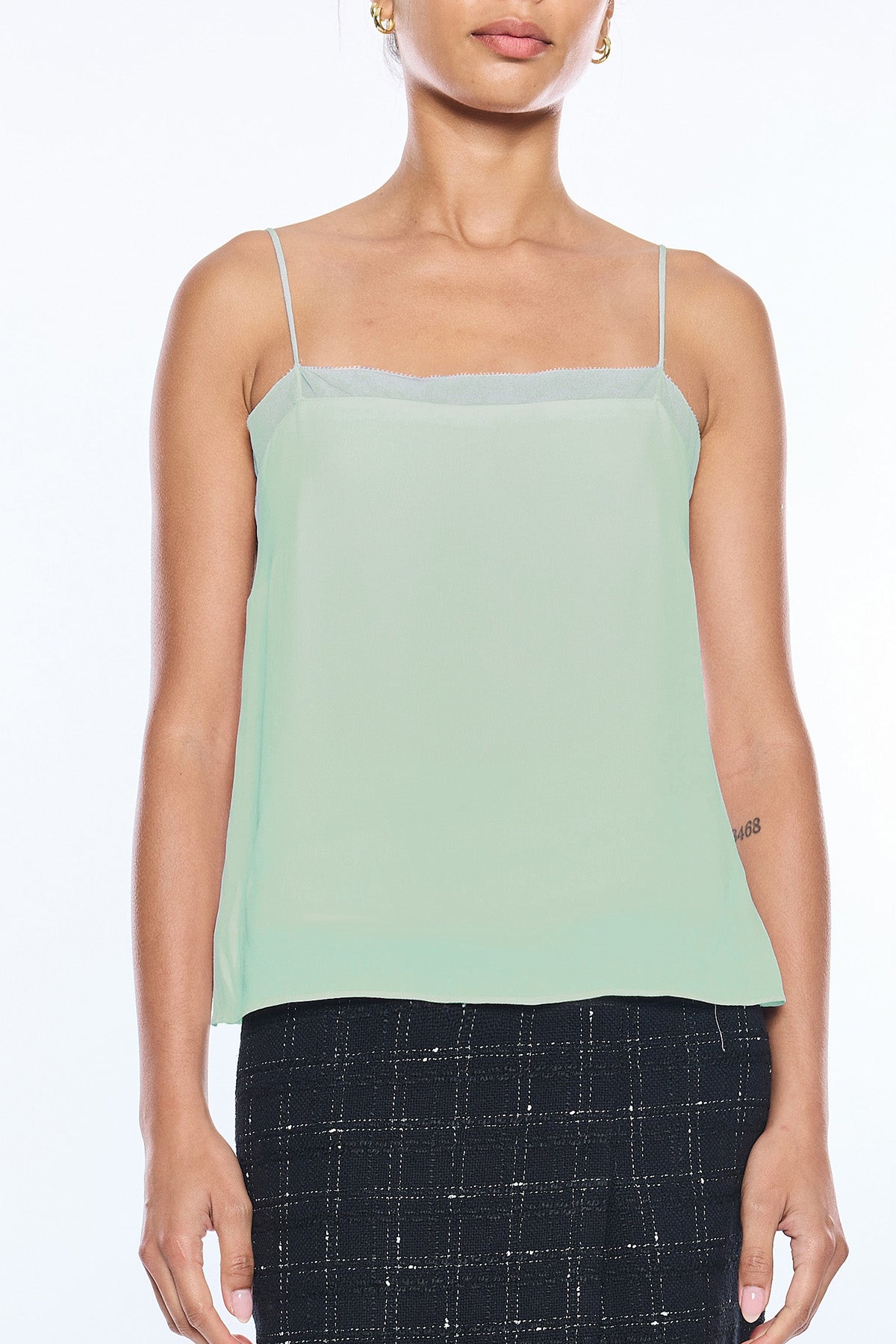 woman in mint green tank top on white background 