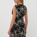Woman wearing a black dress with white floral pattern on a white background