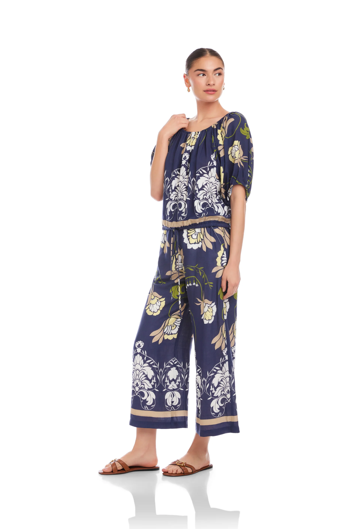 Woman wearing a navy floral jumpsuit on a white background