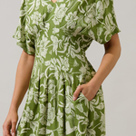 Green floral dress worn by a person on a plain background
