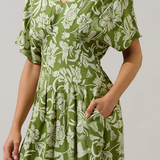 Green floral dress worn by a person on a plain background