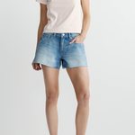Person wearing a light pink t-shirt and denim shorts on a white background