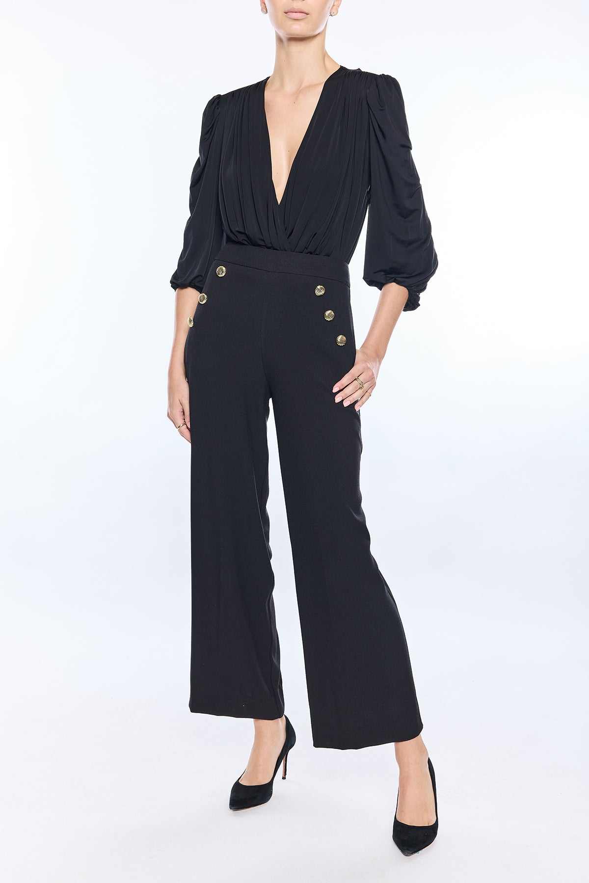 woman in black top and black pants on white background 