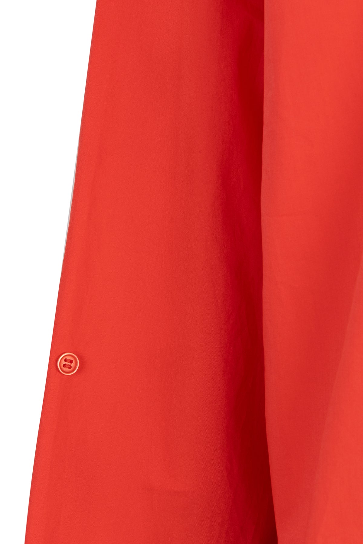 Close-up of a red garment with a button on a white background