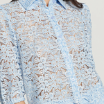 Light blue lace blouse worn by a model on a plain background