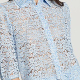 Light blue lace blouse worn by a model on a plain background