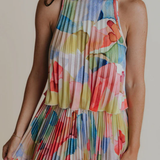 Woman wearing a colorful floral dress against a neutral background