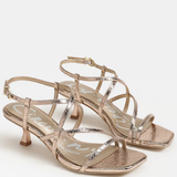 Pair of gold strappy high-heeled sandals on a white background