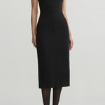 Model wearing black midi dress on an off white background.