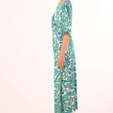 Woman wearing a green and white patterned dress on a white background