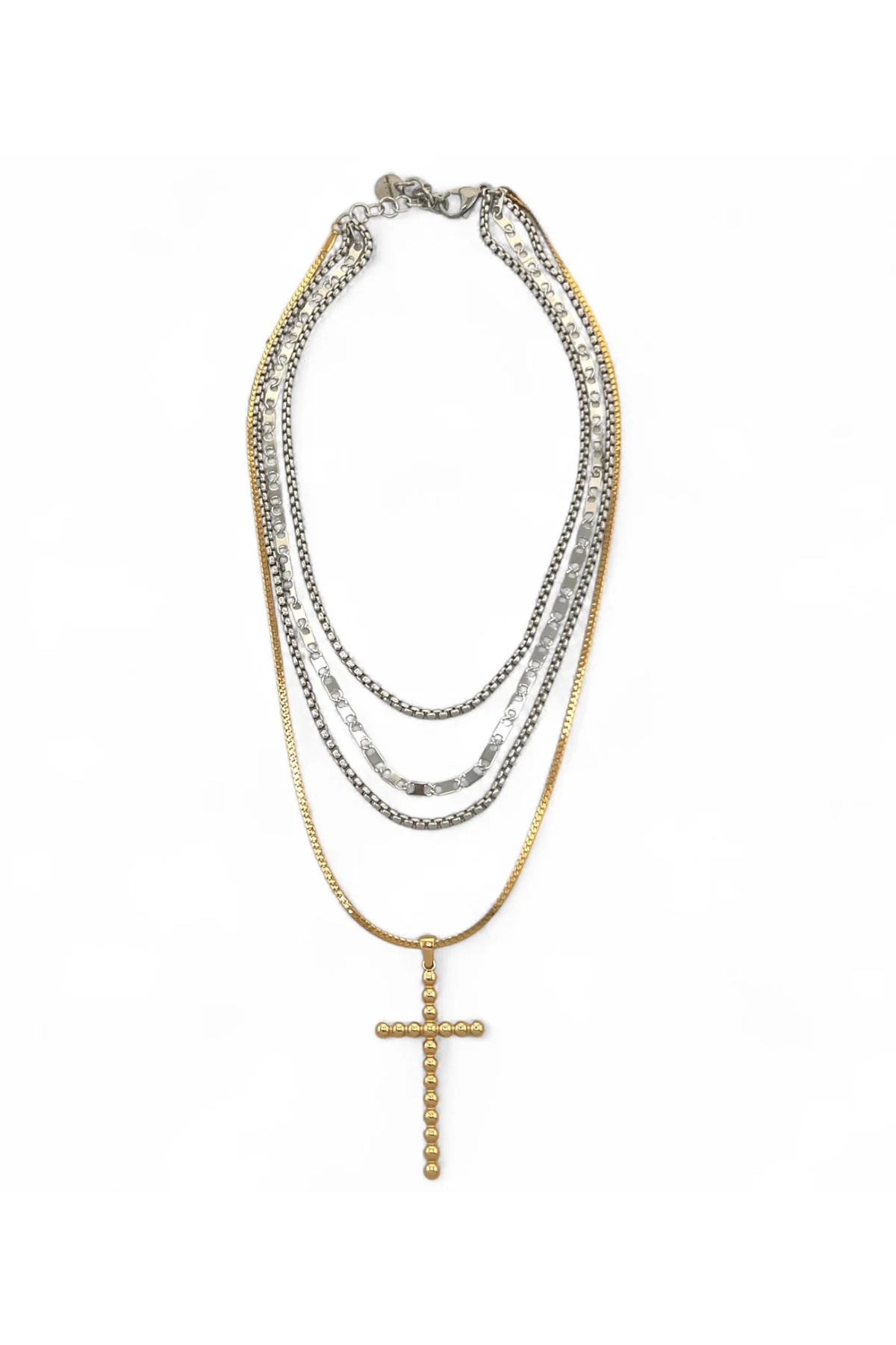 Stack of layered necklaces with a cross pendant on a white background