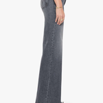 A side profile view of a model wearing high-waisted, wide-leg gray denim jeans with black pointed-toe heels against a plain white background.