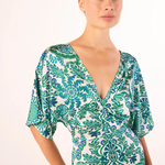 Woman wearing a green and white patterned dress on a white background