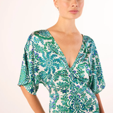 Woman wearing a green and white patterned dress on a white background