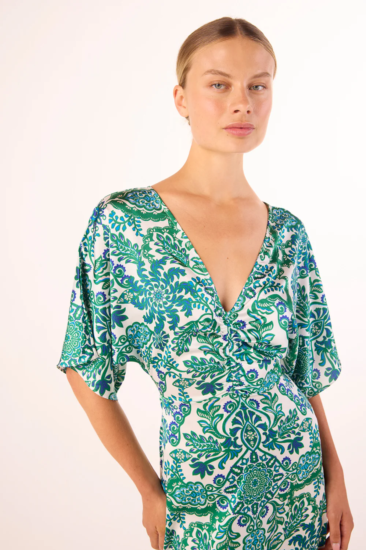 Woman wearing a green and white patterned dress on a white background