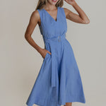 Woman wearing a blue dress against a plain background