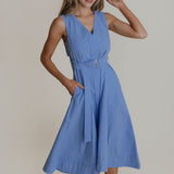 Woman wearing a blue dress against a plain background