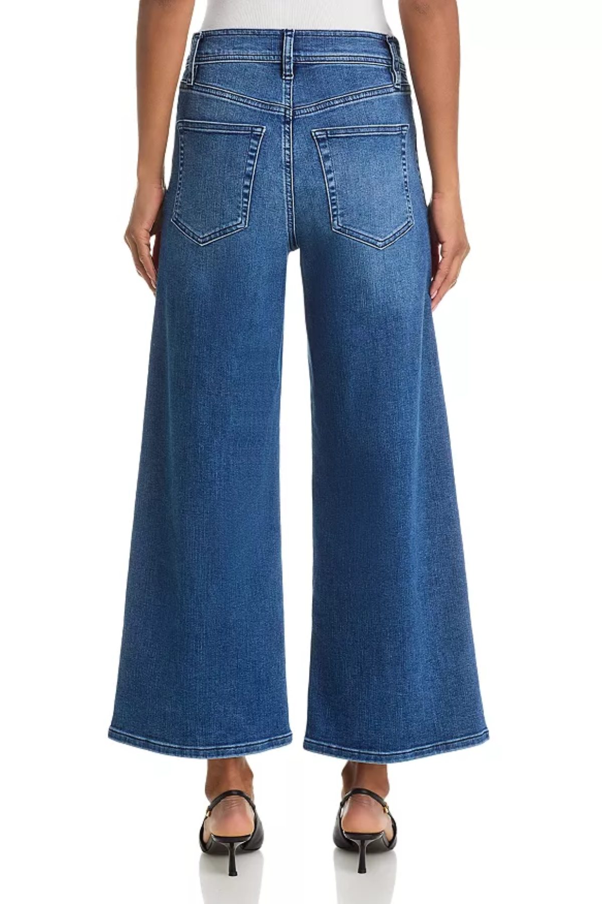 A model shown from the back wearing blue wide-leg denim jeans and black heeled sandals against a plain white background.