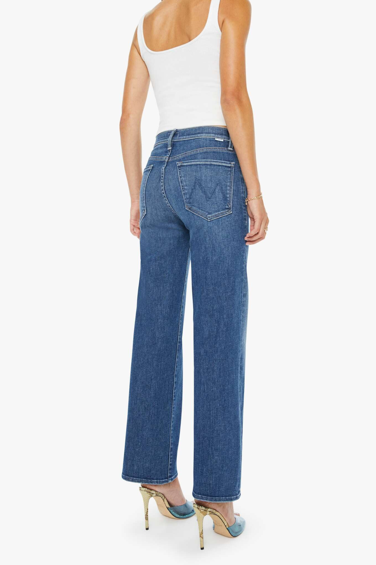 Woman wearing blue jeans and a white top on a white background