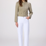 Woman wearing a green jacket and white pants on a white background
