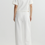 Person wearing a white outfit on a plain background
